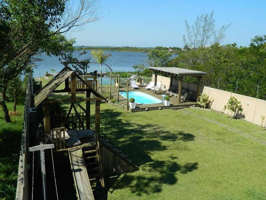 Casa na beira da lagoa com piscina e rampa para embarcações